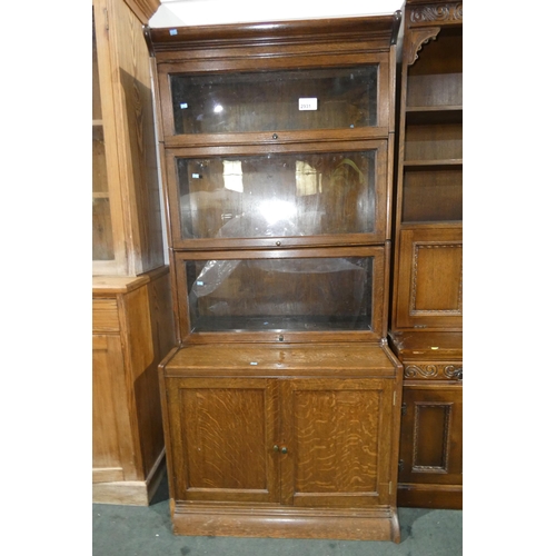 2931 - A vintage Oak sectional bookcase with three drop-leaf glazed doors and two panel doors below, approx... 