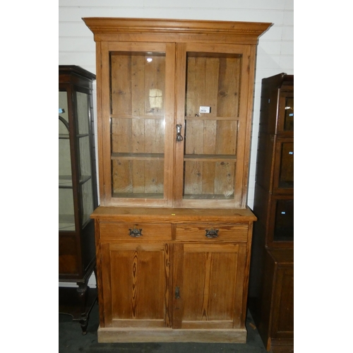 2932 - An Edwardian pitch pine kitchen cabinet with two glazed doors enclosing shelves, 2 short drawers and... 