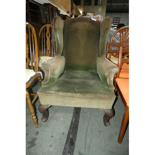 2974 - A green upholstered winged armchair