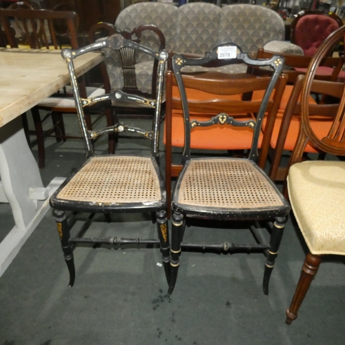 2978 - An Edwardian ebonised a bedroom chair with a cane seat and mother of pearl inlay and a similar eboni... 