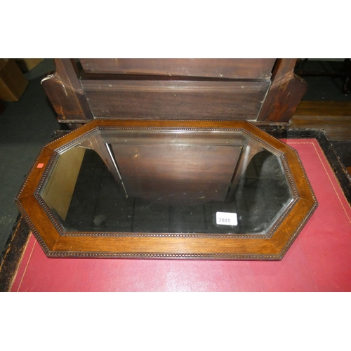 3005 - An octagonal bevelled wall mirror in an oak frame