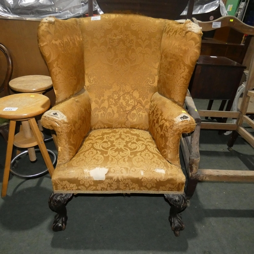 3032 - A large winged armchair on cabriole legs with gold coloured upholstery