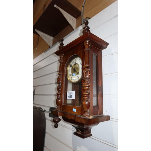 2919 - A small mahogany case wall clock with a glass door