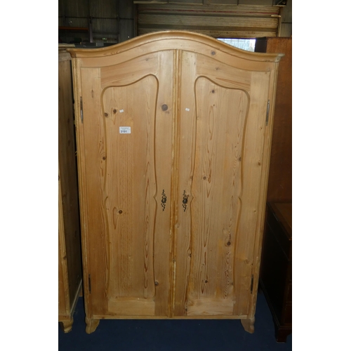 3191 - A pine wardrobe with two panel doors enclosing hanging space and a fitted interior, approximately 11... 