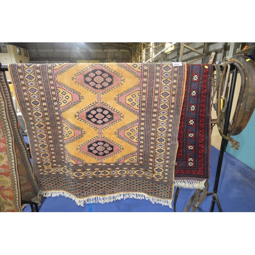 3084 - A red round oriental style rug with white patterned centre medallion and a gold ground multi-coloure... 