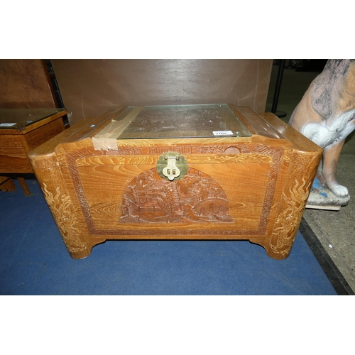 3100 - A heavily carved oriental camphor wood chest with a lift lid