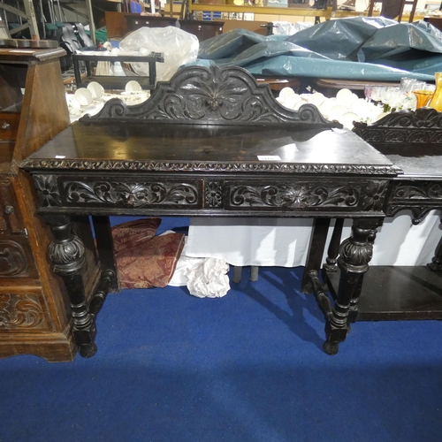 3119 - A heavily carved dark oak hall table with two drawers and bulbous legs, approximately 106cm wide