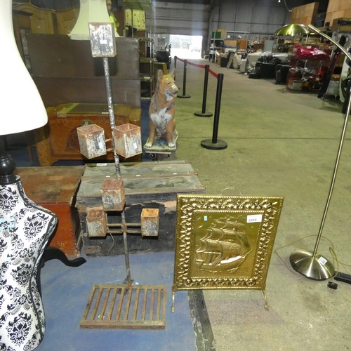 3068 - A decorative embossed brass fire screen and a wrought iron plant holder