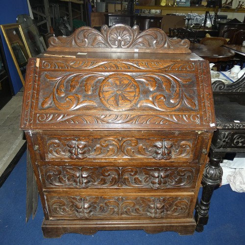 3120 - A heavily carved dark oak Bureau with a fall front enclosing a fitted interior and 3 drawers under, ... 