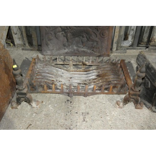 3123 - A heavy cast iron fire grate with a pair of decorative fire dogs