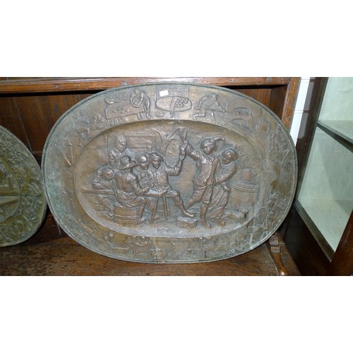 2935 - 2 antique decorative heavily embossed brass relief oval wall plates. The larger is approx 72 x 53cm ... 