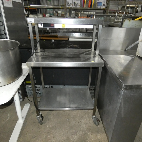 1192 - A mobile commercial stainless steel catering type table with shelf beneath and heated gantry above a... 