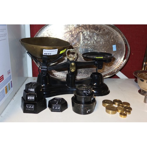 4011 - A set of black enamelled kitchen scales with brass pan and weights, an oval silver plated tray and a... 