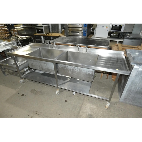 2186 - A large commercial stainless steel twin deep sink unit with shelf beneath approx 240x70cm