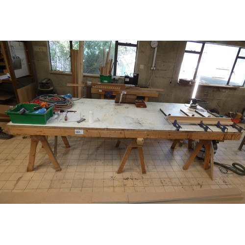 181 - A large flat work table sitting on three trestle supports, approx 305 x 122 x 96cm high