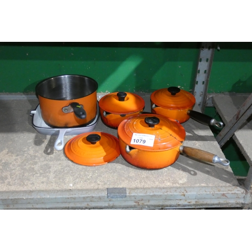 1079 - 3 Le Creuset pots in orange, 4 lids, a grey skillet etc. Contents of 1/2 a shelf