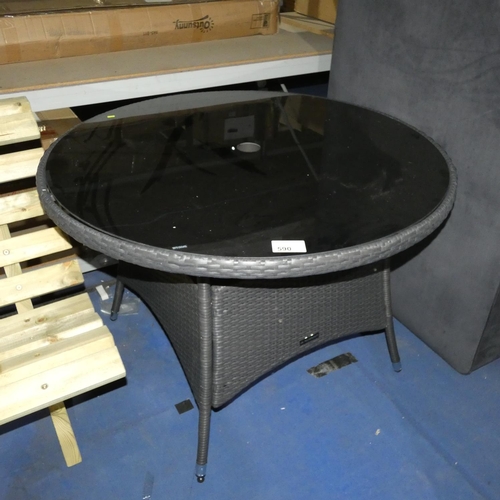 590 - 1 x synthetic rattan table with black glass top diameter approx 100cm