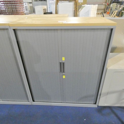 1334 - A grey metal tambour cabinet with light wood effect top measuring approx 120cm x 47cm x 120cm