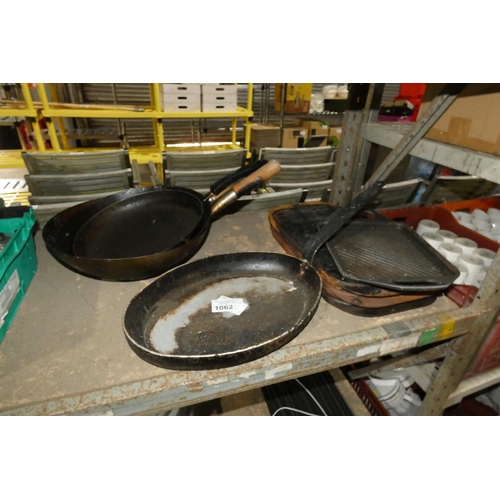 1062 - A quantity of various catering related items including cast griddle tops, woks, frying pan etc