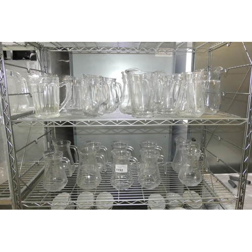 1192 - A quantity of various glass water jugs, contents of 2 shelves