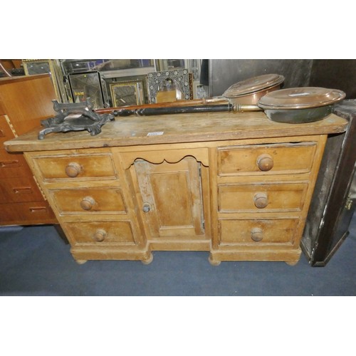A vintage pine dresser base with six side drawers and a central