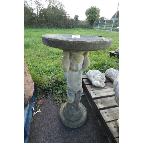 1327 - A round concrete bird bath held by a cherub