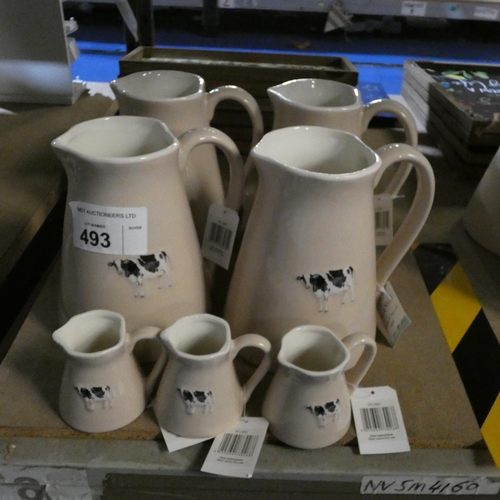 493 - 4 x large bovine patterned water jugs and 3 smaller milk jugs