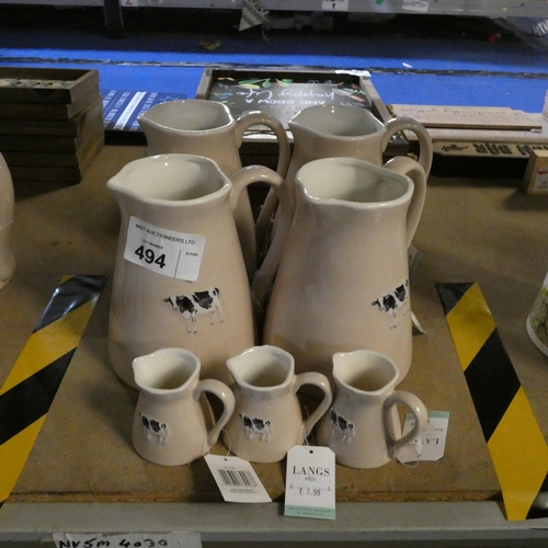 494 - 4 x large bovine patterned water jugs and 3 smaller milk jugs