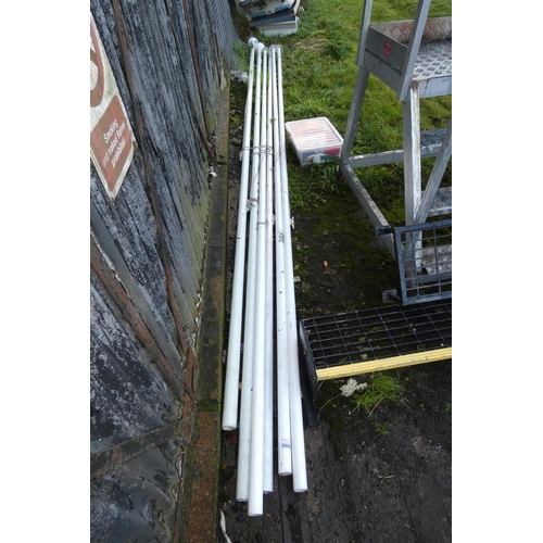 6000 - 6 x Various flag poles each measuring approx 6m tall and a quantity of various flags