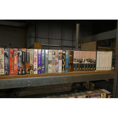 2104 - A quantity of various VHS video cassettes and vinyl records. Contents of 1 bay / 4 shelves and buyer... 