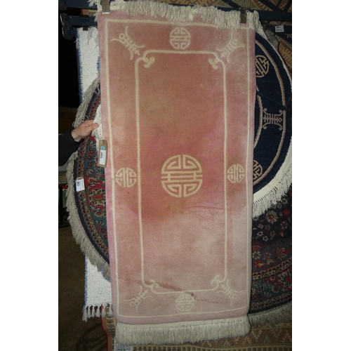 265 - A pink ground patterned rug approx 70*150cm faded on one end