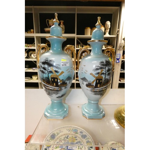 3179 - A pair of blue ground windmill decorated urns with handles and lids