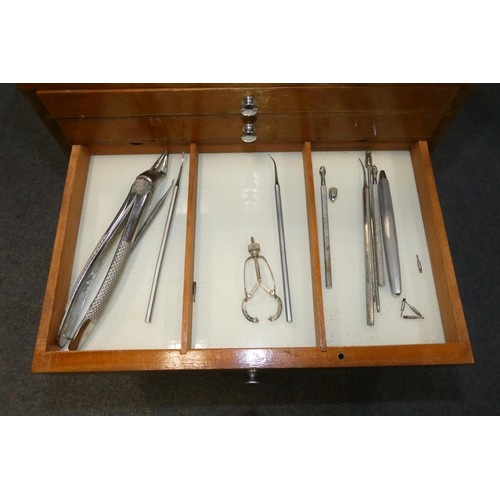 3095 - A vintage dentist's seven drawer mahogany cabinet containing dental instruments and equipment