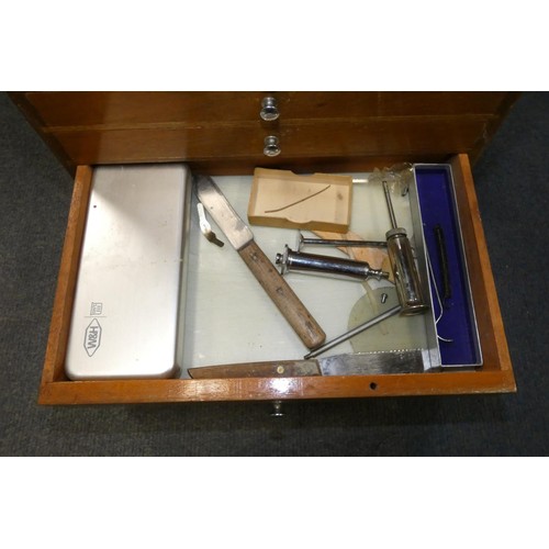 3095 - A vintage dentist's seven drawer mahogany cabinet containing dental instruments and equipment