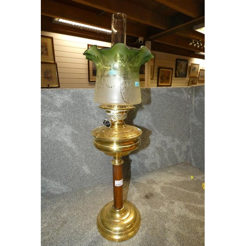 3180 - A vintage brass column oil lamp with a green glass shade