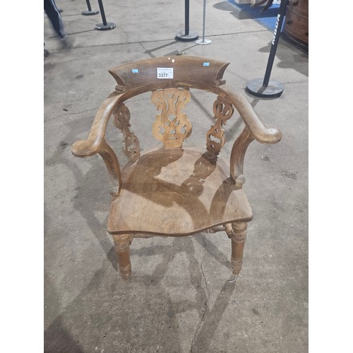 3377 - A vintage smokers bow chair with a wooden seat