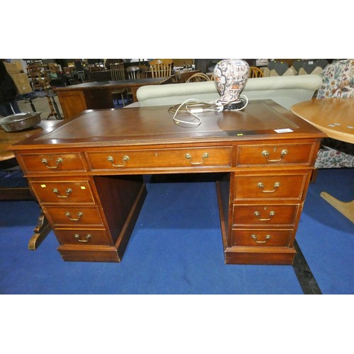 3395 - A mahogany rectangular topped pedestal desk with one central and eight side drawers with brass drop ... 