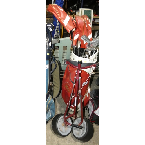 3065 - 1 x red golf caddy bag containing a quantity of Wilson golf clubs