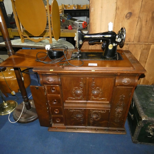 A vintage Singer treadle sewing machine in a decorative carved mahogany ...