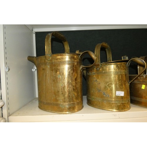 3038 - Four large graduated brass watering cans