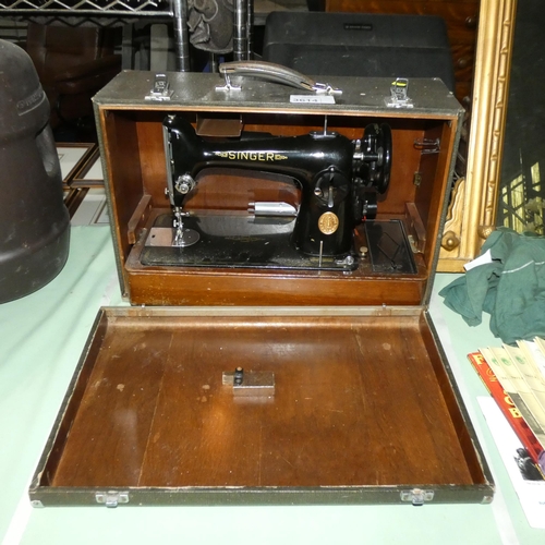 A vintage Singer hand sewing machine in carry case