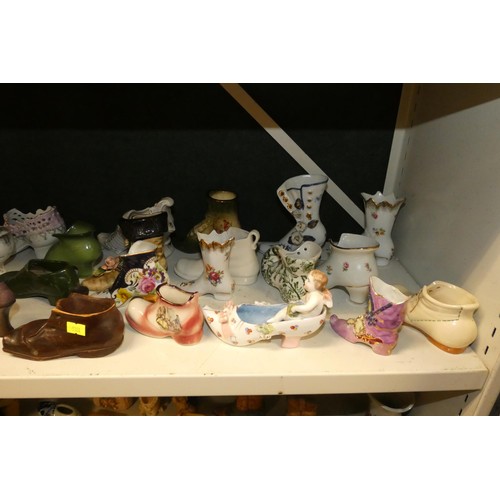 3076 - A large quantity of miscellaneous decorative vintage china shoes and boots (three shelves)