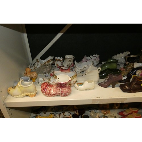 3076 - A large quantity of miscellaneous decorative vintage china shoes and boots (three shelves)