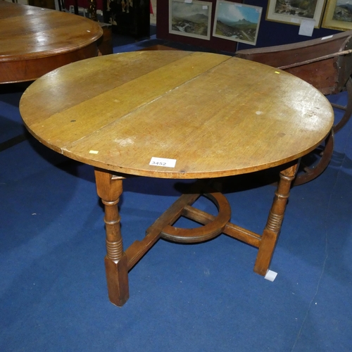 3452 - A vintage golden oak circular topped gate leg table, approximately 112 centimeters diameter