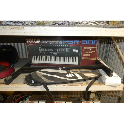 2404 - A vintage boxed Yamaha keyboard type PSR-300 with stand, pogo stick, badminton rackets,