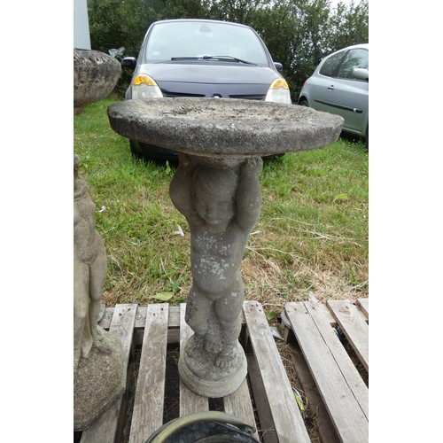 2390 - A weathered concrete bird bath on a cherub shaped pedestal