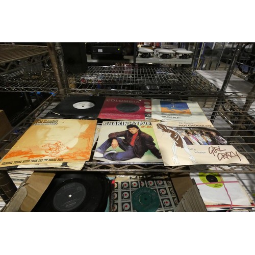 2369 - A quantity of various 7 inch single vinyl records and audio tapes. Contents of 2 shelves