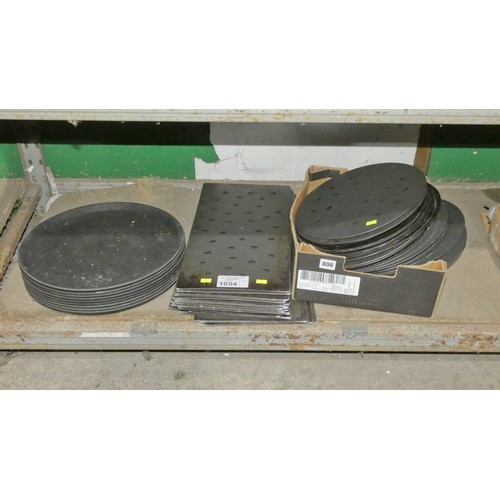 1054 - A quantity of various pizza cooking disks, trays and food trays