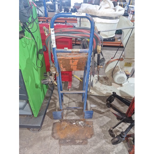 5367 - A twin gas bottle trolley with hose, gauges and a cutting torch. Please note the two gas bottles sho... 