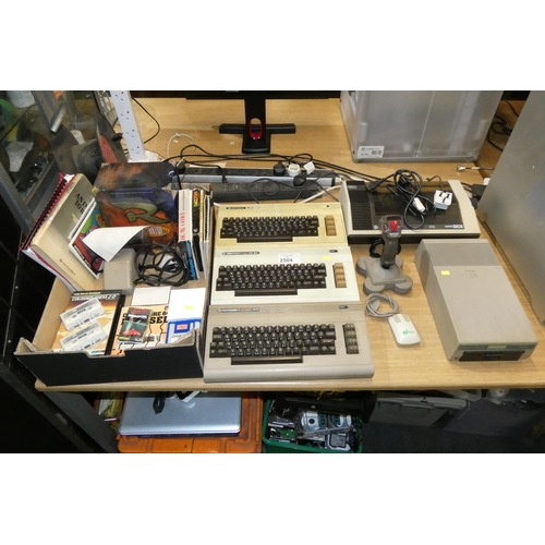 2504 - A quantity of various vintage computers including a Commadore 64, 2 x Vic 20's, games, Commodore pri... 